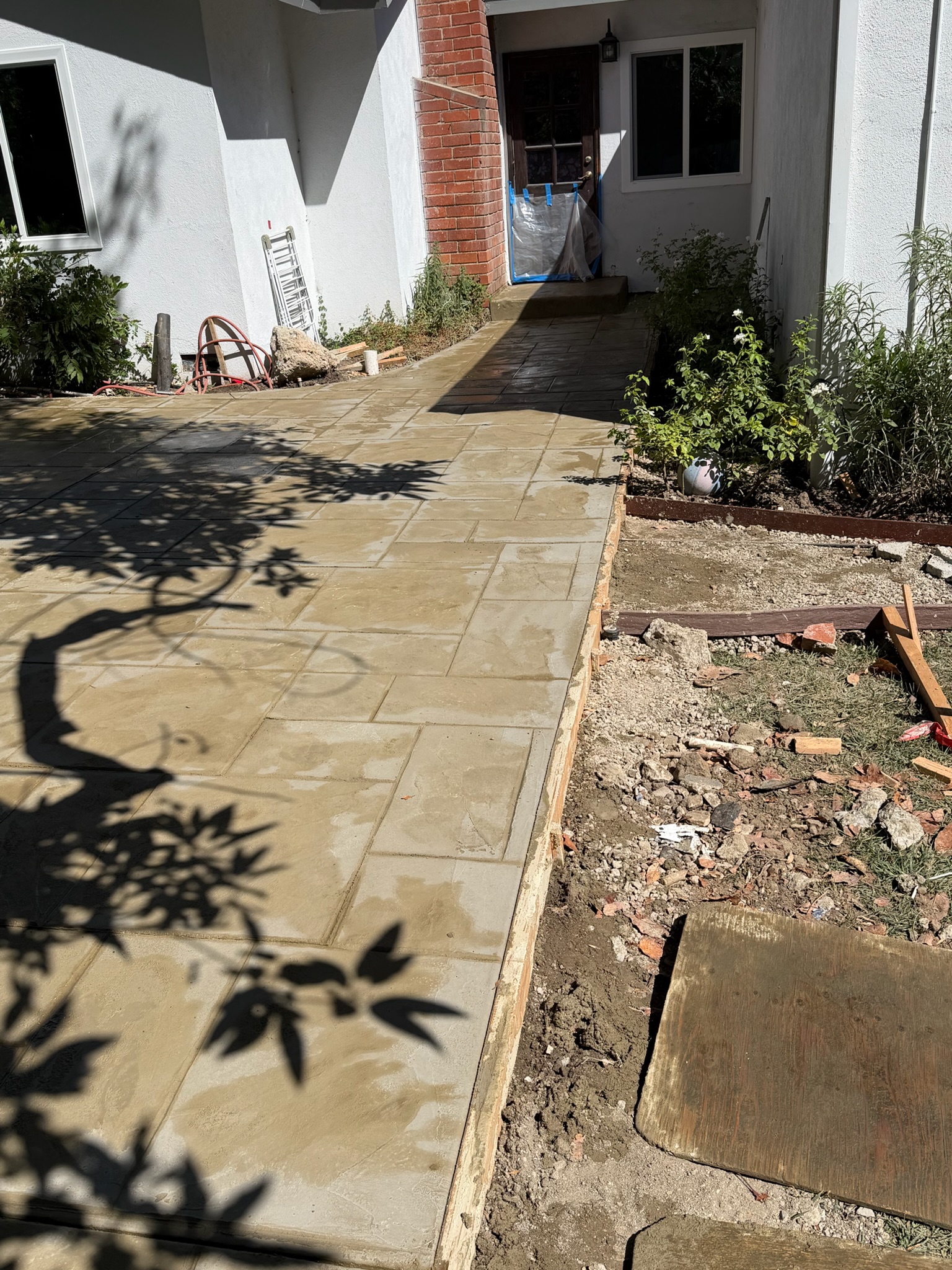 Stamped concrete with tree shadows at a Cedar and Stone outdoor project